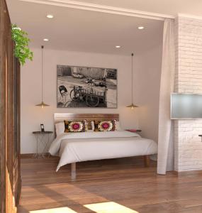 塔什干艺术一室公寓的卧室配有一张床,墙上挂有绘画作品