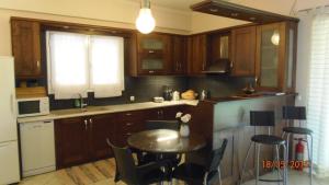 科洛皮奥Green Villa near Airport的厨房配有木制橱柜和桌椅