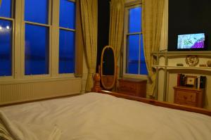 斯特兰拉尔Briar Brae Bed & Breakfast的一间卧室配有一张带镜子和窗户的床