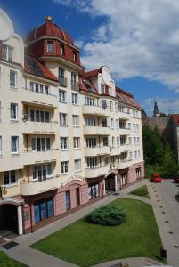 奥尔什丁3-Pokojowy Apartament Villa Park - Top Location的一座白色的大建筑,有红色的屋顶