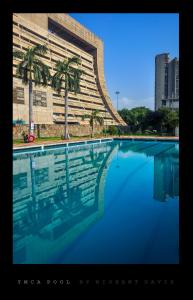 新德里新德里YMCA观光客旅馆的一座楼前棕榈树游泳池