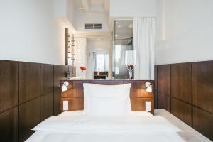 慕尼黑慕尼黑红宝石百合酒店的一间卧室配有两张床和镜子