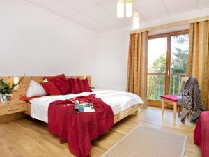 KaumbergBrandtner Komfortzimmer的一间卧室配有一张床铺,床上铺有红色毯子