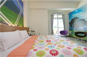 台东台东的家民宿的一间卧室配有一张大床和色彩缤纷的被子