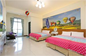 台东台东的家民宿的一间卧室配有两张床,并画有热气球