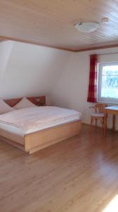 蒂蒂湖-新城Pension Forsthaus Täle的一间卧室配有一张床、一张桌子和一个窗户。