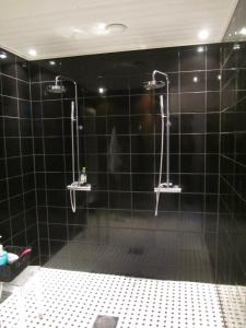 NivalaHotelli Huiskankorpi Boutique Hotel的浴室设有黑色瓷砖淋浴。
