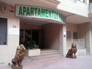 托雷维耶哈Apartamentos Turísticos Fresno的两座狮子雕像,在一座建筑前
