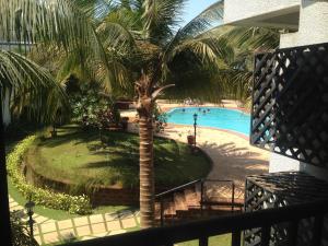 阿伯来Pool and Garden Facing Apartment in Riviera Foothills Near Baga, Arpora的享有游泳池的顶部景色,游泳池拥有棕榈树