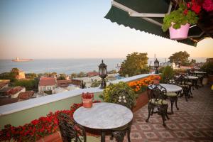 伊斯坦布尔伊斯坦布尔德尔萨德特酒店的阳台配有桌椅,享有海景。