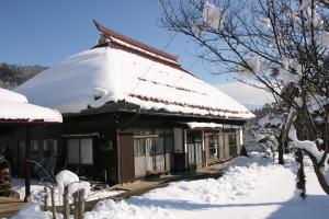 中野市Madarao Farm的雪覆盖的房屋,屋顶