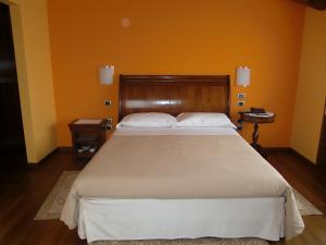CastelcuccoLocanda da Gerry的一间卧室配有一张带橙色墙壁的大床