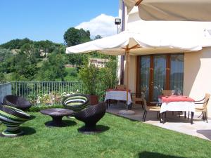 CastelcuccoLocanda da Gerry的庭院配有桌椅和遮阳伞。