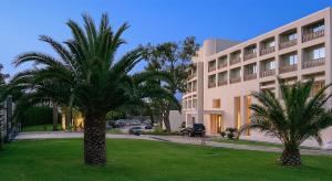 阿纳维索斯度假广场酒店的一座建筑前的棕榈树