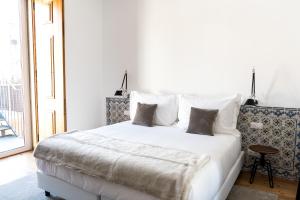里斯本芙洛拉希亚多公寓的卧室配有带枕头的大型白色床