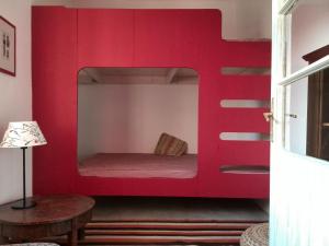 NémetbarnagKőpajta Vendégház的一张红色双层床,位于带桌子的房间