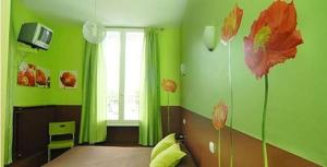 FeursL'Hôtel L'Astrée的绿色客房,墙上挂着鲜花的床