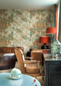埃因霍温Little Grand的客厅配有桌椅和壁纸