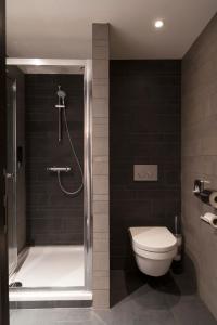 布鲁塞尔城市市中心旅舍的带淋浴、卫生间和浴缸的浴室