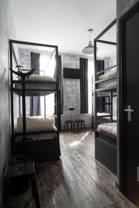 布鲁塞尔城市市中心旅舍的客房设有两张双层床和一张桌子。