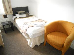 亚姆Yarm View Cottages的一间卧室配有一张床和一把椅子