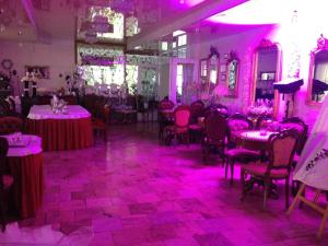 PleszewAcwador的一间充满桌子和粉红色灯光的房间