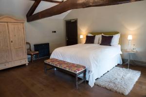 米德尔赫姆The Priory的卧室设有一张白色大床和木地板