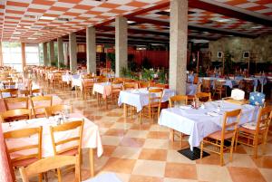 伯德古拉奥罗拉酒店的一间设有白色桌椅的用餐室