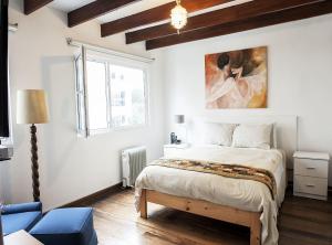 利马Departamento Loft en Olivar de San Isidro的卧室配有一张床,墙上挂有绘画作品