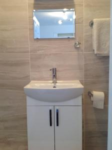 罗姆福特Repton Private Hotel的浴室设有白色水槽和镜子