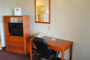 埃德蒙顿伊科诺米酒店的一张桌子,电视机和椅子放在房间里