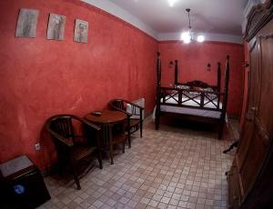 塞哥维亚豪斯特里亚纳杜拉酒店的一间拥有红色墙壁和桌椅的用餐室