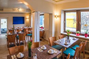慕尼黑阿霍恩酒店的餐厅设有桌椅和大窗户。