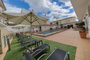 科尼尔-德拉弗龙特拉科尼尔勒托公寓酒店的一个带椅子和遮阳伞的庭院和一个游泳池