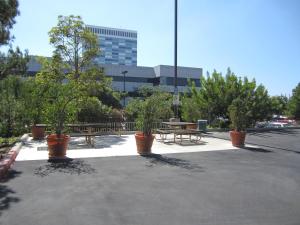 埃尔塞贡多亚美利卡延住酒店 - 洛杉矶 - 洛杉矶国际机场 - 埃尔塞贡多的一个带盆栽树木和野餐桌的停车场