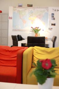 汉堡MAC城市旅舍的一间设有五颜六色椅子和一张带花的桌子的房间