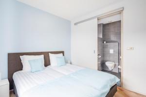 MeliskerkeMeliskerke vakantiewoning的卧室内的白色床和蓝色枕头