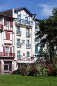 圣让-德吕兹乐莱斯圣雅克酒店的带阳台的大型白色建筑和棕榈树