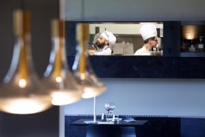 夸特罗卡斯泰拉卢坎达马蒂尔德酒店的坐在厨房里的人,在镜子里