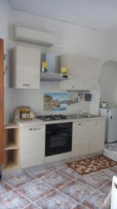 阿特拉尼弗朗西斯之家酒店的厨房配有白色橱柜和炉灶烤箱。
