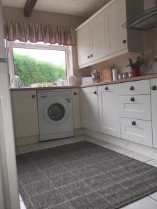 切斯特Fir Tree Cottage的厨房配有洗衣机和窗户。