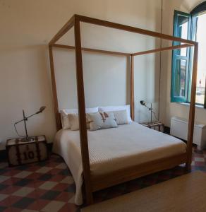 巴格里亚Le stanze del Capostazione的一间卧室设有一张天蓬床和一张可调节的地板。
