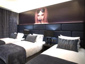 戈尔韦住宅酒店的一间设有两张床的酒店客房,并装饰有一幅女画