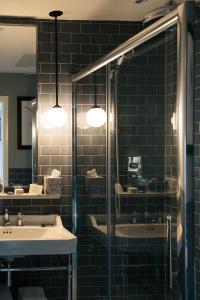 邓莱里哈丁顿酒店的一间带水槽和玻璃淋浴的浴室