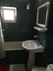 克利默内什蒂Apartament Aqua的浴室配有盥洗盆、镜子和浴缸