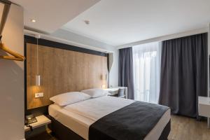 卢布尔雅那M酒店的酒店客房设有一张床和一个大窗户