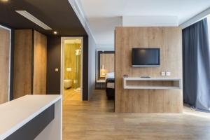 卢布尔雅那M酒店的带电视的客厅和卧室。