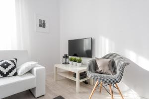 华沙P&O Apartments Andersa INTRACO的白色的客厅配有椅子和电视