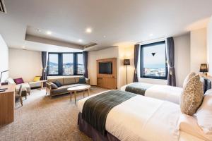 小樽Nord 小樽酒店的酒店客房,设有两张床和一张沙发