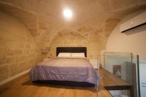 莱切Suite del Teatro Romano的卧室配有一张石墙床
